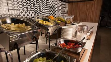 A buffet setup with various food items including fruits and vegetables.