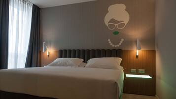 Une chambre d’hôtel avec un grand lit, deux tables de chevet, un luminaire fixé au mur et une œuvre d’art décorative.
