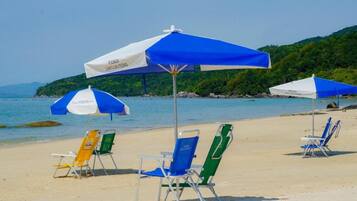 On the beach, white sand, sun-loungers, beach umbrellas