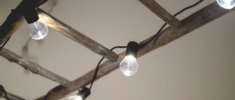 A ceiling with wooden branches supporting clear glass bulbs.