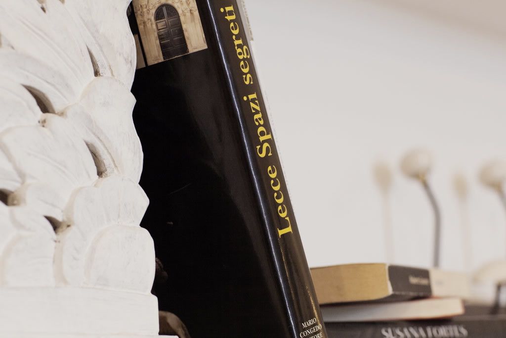 Een boek met de titel 'Leccce Spazi segreti' van Mario Congedo op een plank met andere boeken.