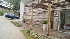 A building with a wooden facade and a covered entrance area. - Apartamentos Charm Centro Gramado (Gramado)