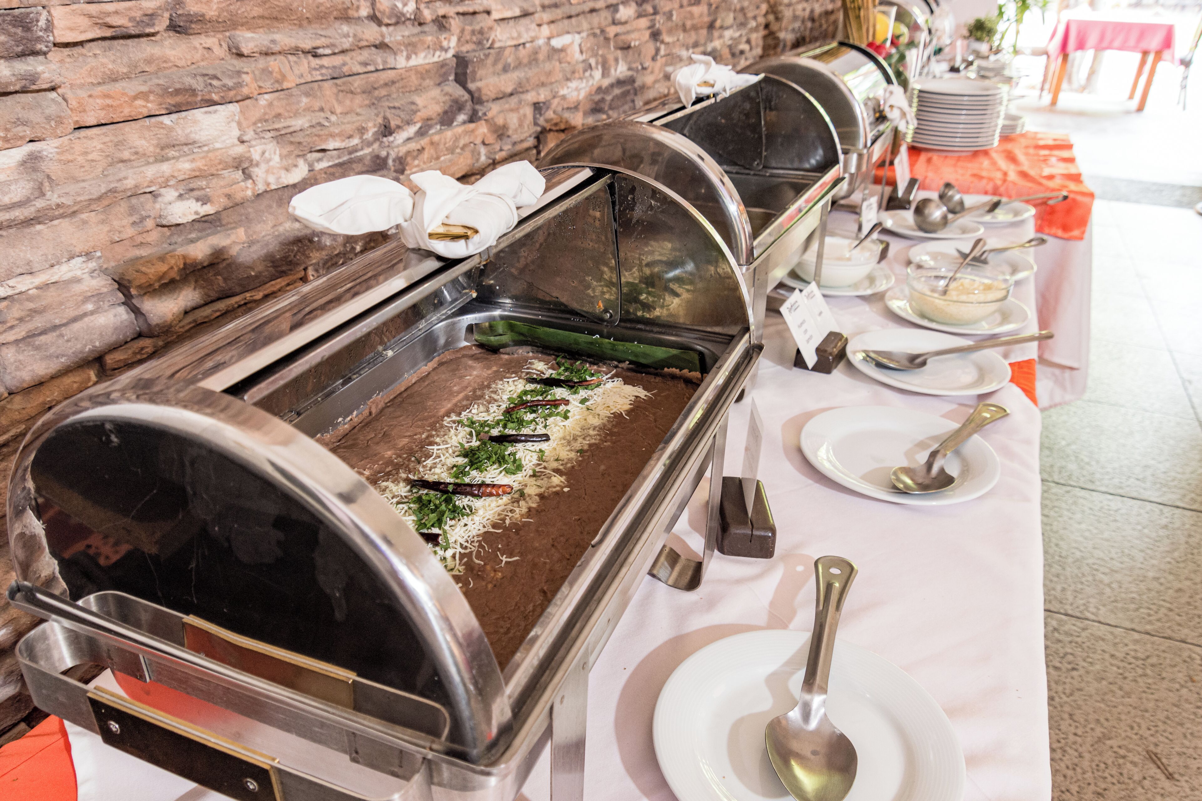 A buffet setup with multiple serving stations, including a variety of dishes and utensils.