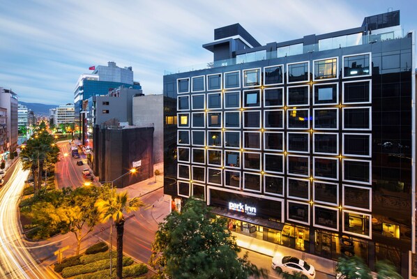 Un hôtel moderne avec une façade composée d’une grille de fenêtres et une enseigne « Park Inn ».