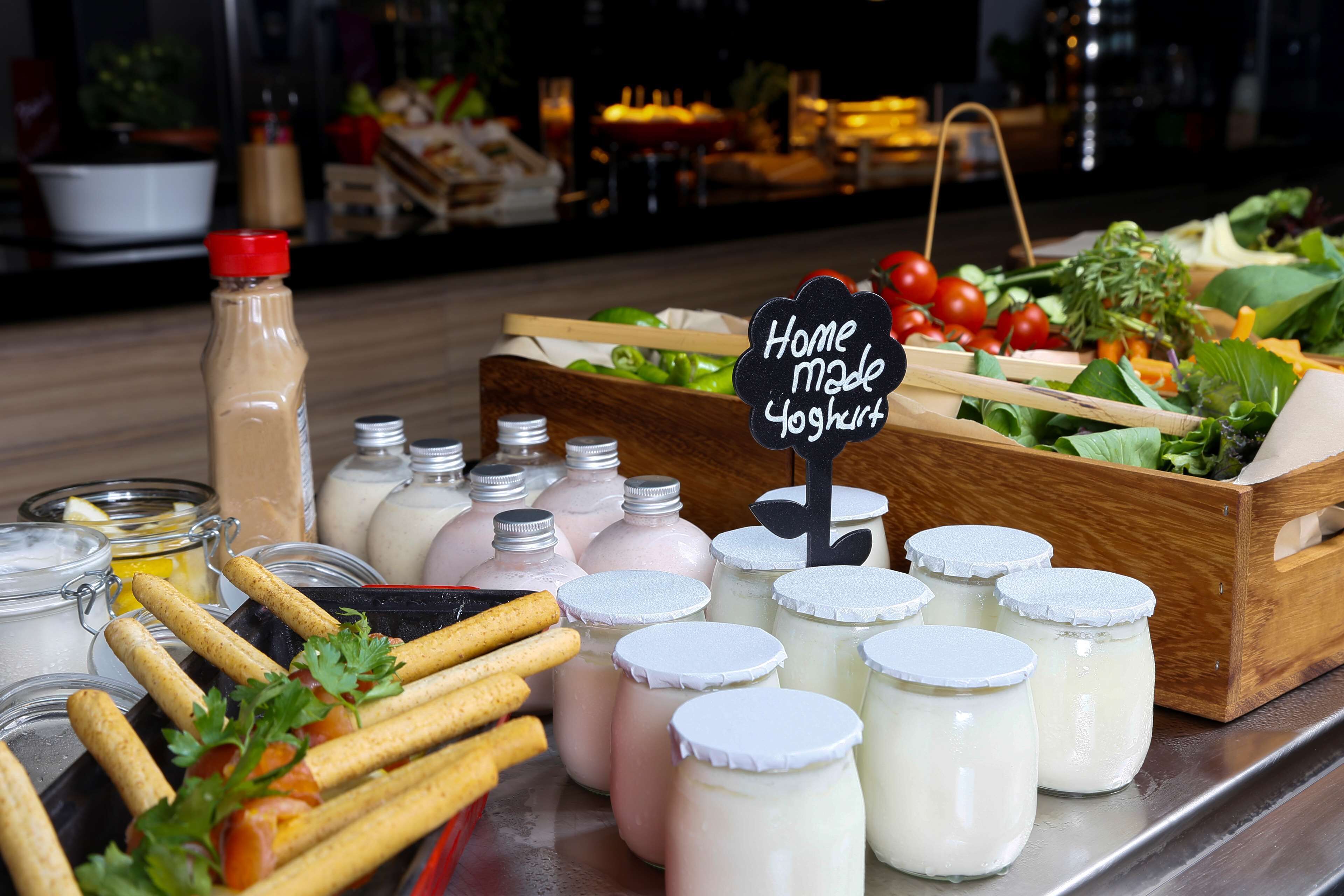A display of homemade yogurt, fresh vegetables, and crackers.