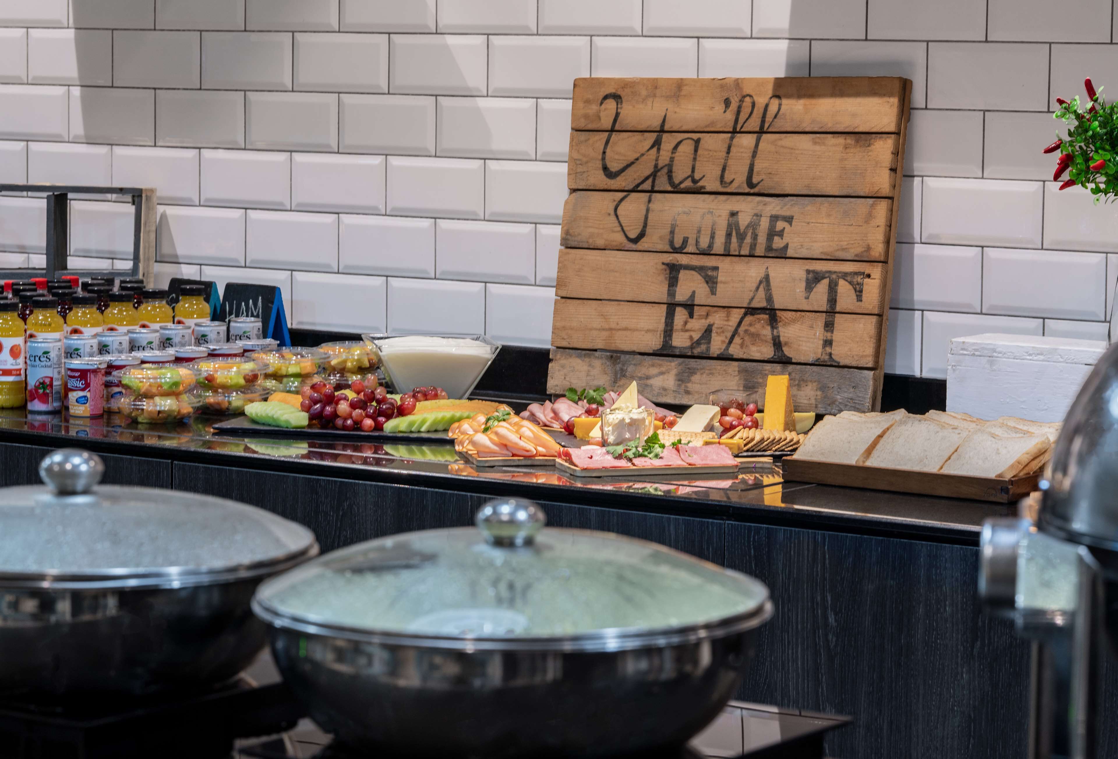 Ein Buffet mit verschiedenen Speisen und einem Schild, auf dem steht: "Y'all come eat".