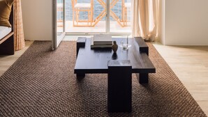 A room with a large sliding glass door leading to a balcony with a view of the sea. - White Exclusive Suite & Villas (Lagoa)