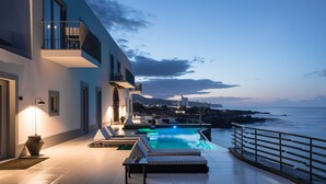 A modern building with a pool and a view of the sea. - White Exclusive Suite & Villas (Lagoa)