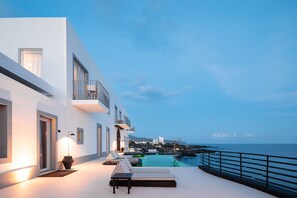 A modern building with a pool and outdoor seating. - White Exclusive Suite & Villas (Lagoa)
