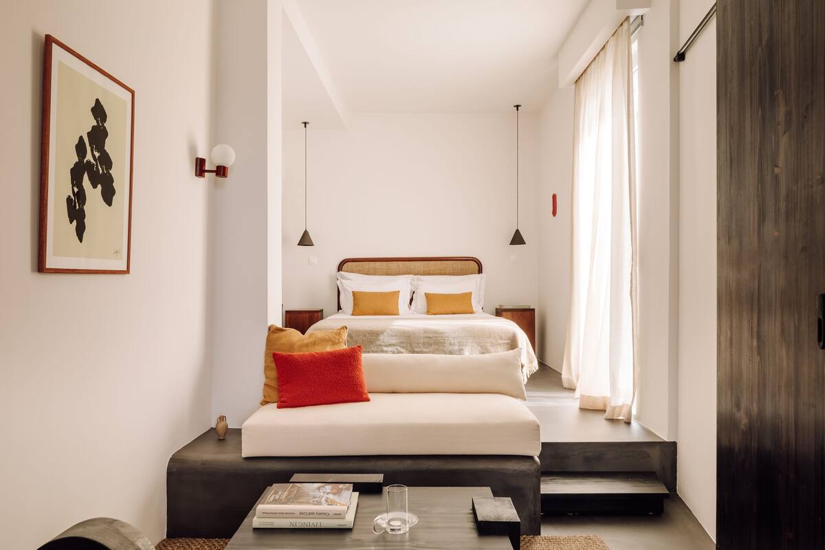 A modern bedroom with a large bed, bedside tables, a bedside lamp, and a framed artwork on the wall.