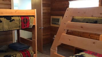 A wooden cabin room with bunk beds, a window, and a door.