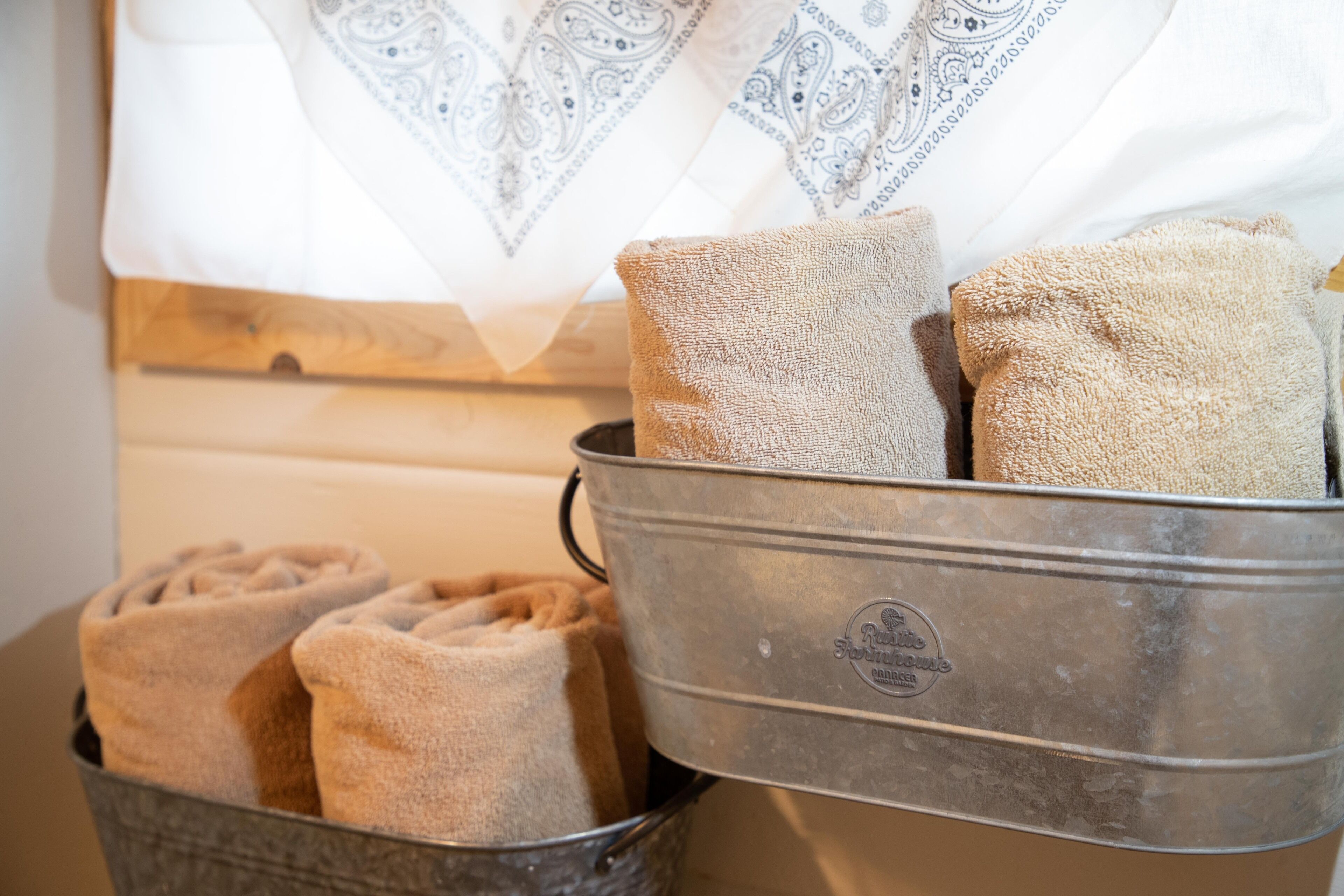 A metal container with folded towels and a patterned white cloth.