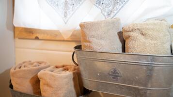 A metal container with folded towels and a patterned white cloth.