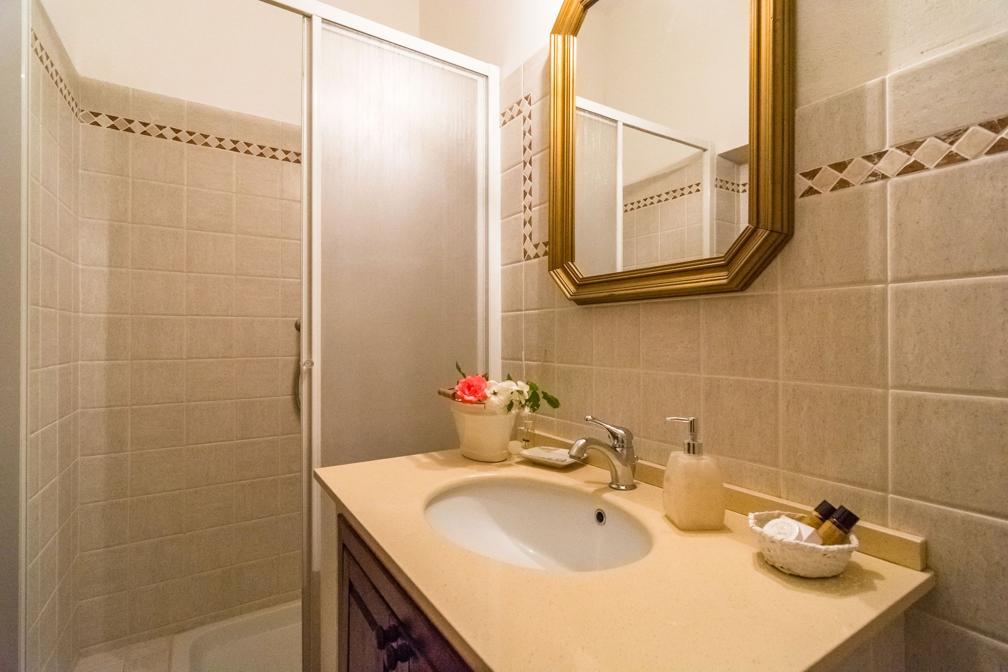 A bathroom with a sink, mirror, and toiletries.