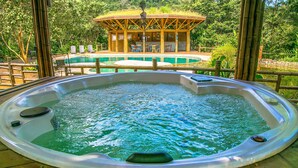 Un jacuzzi con un muelle de madera y un pabellón al fondo.
