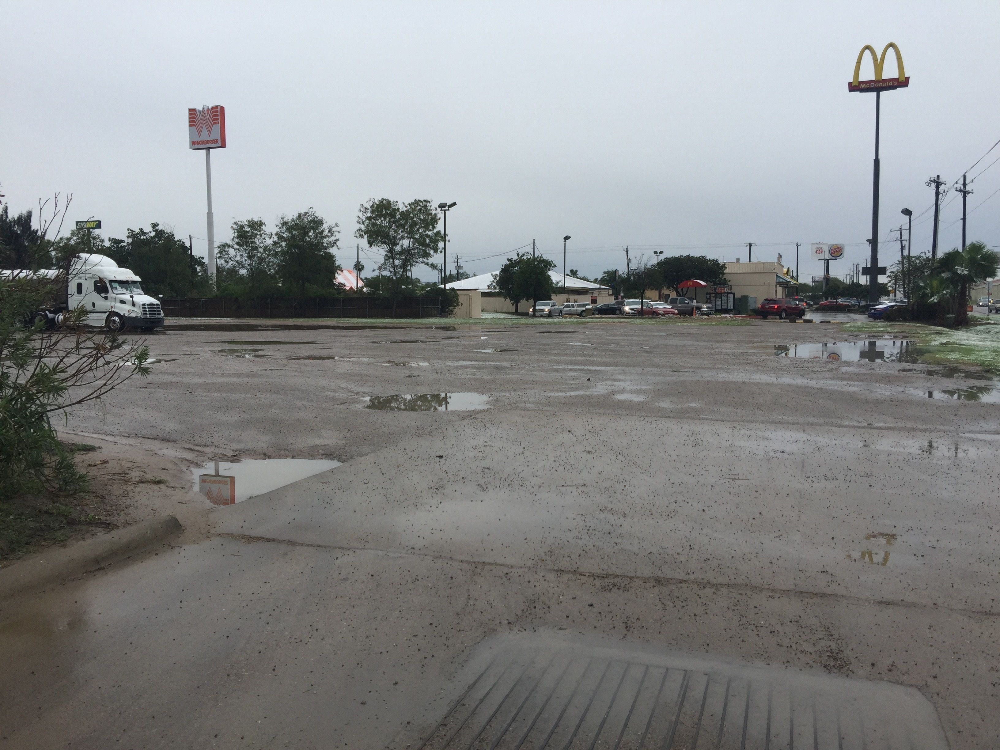 A large, open parking lot with a McDonald's sign in the distance.