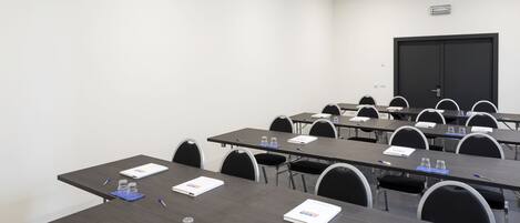 A conference room with multiple tables, chairs, and nameplates.