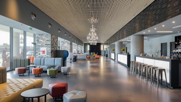 Een moderne lounge met zitplaatsen, een bar en uitzicht op het omliggende landschap.