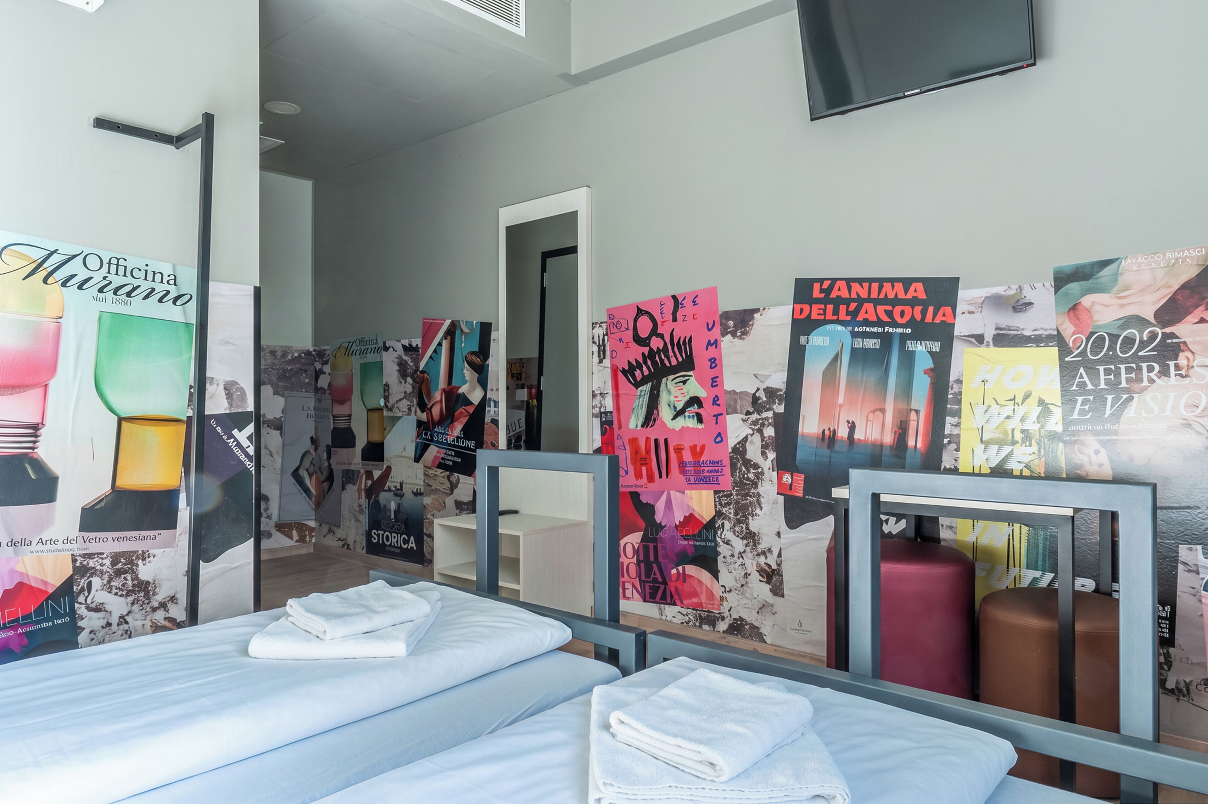 Habitación de hotel con dos camas, un televisor de pantalla plana y obras de arte en las paredes.