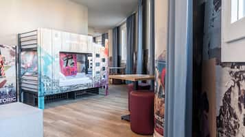 A modern interior with a bed, a table, and a red stool.