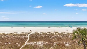 A beach with a clear sky, sandy shore, and sparse vegetation. - Premier Townhomes by Panhandle Getaways (Panama City Beach)