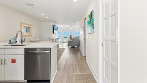 A modern kitchen with a dishwasher, a sink, and a fire safety sign. - Premier Townhomes by Panhandle Getaways (Panama City Beach)