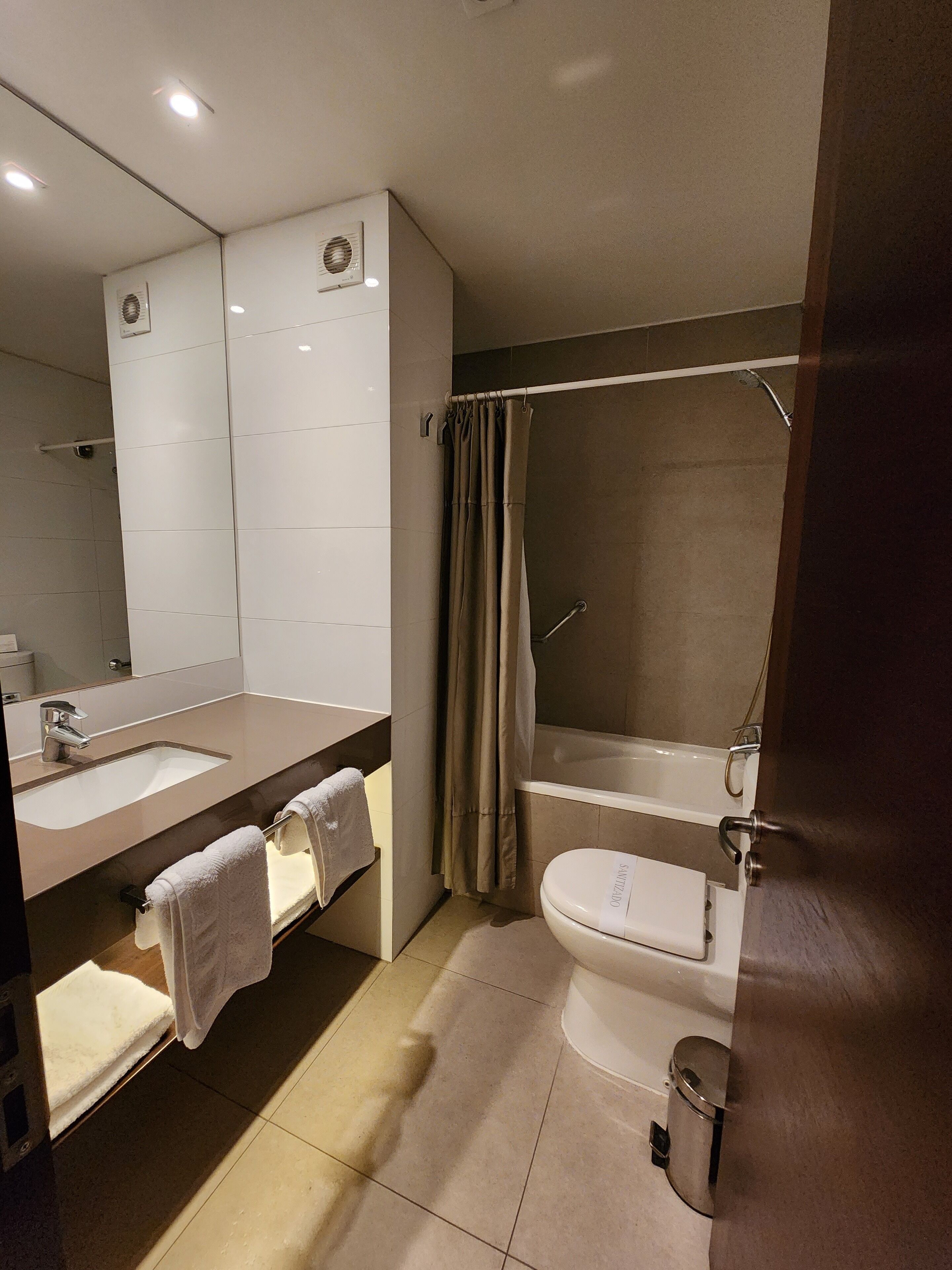 Un baño moderno con lavamanos doble, bañera y retrete.