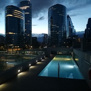 A rooftop pool with a glass barrier, surrounded by modern high-rise buildings. - Hotel los Españoles Plus (Santiago)