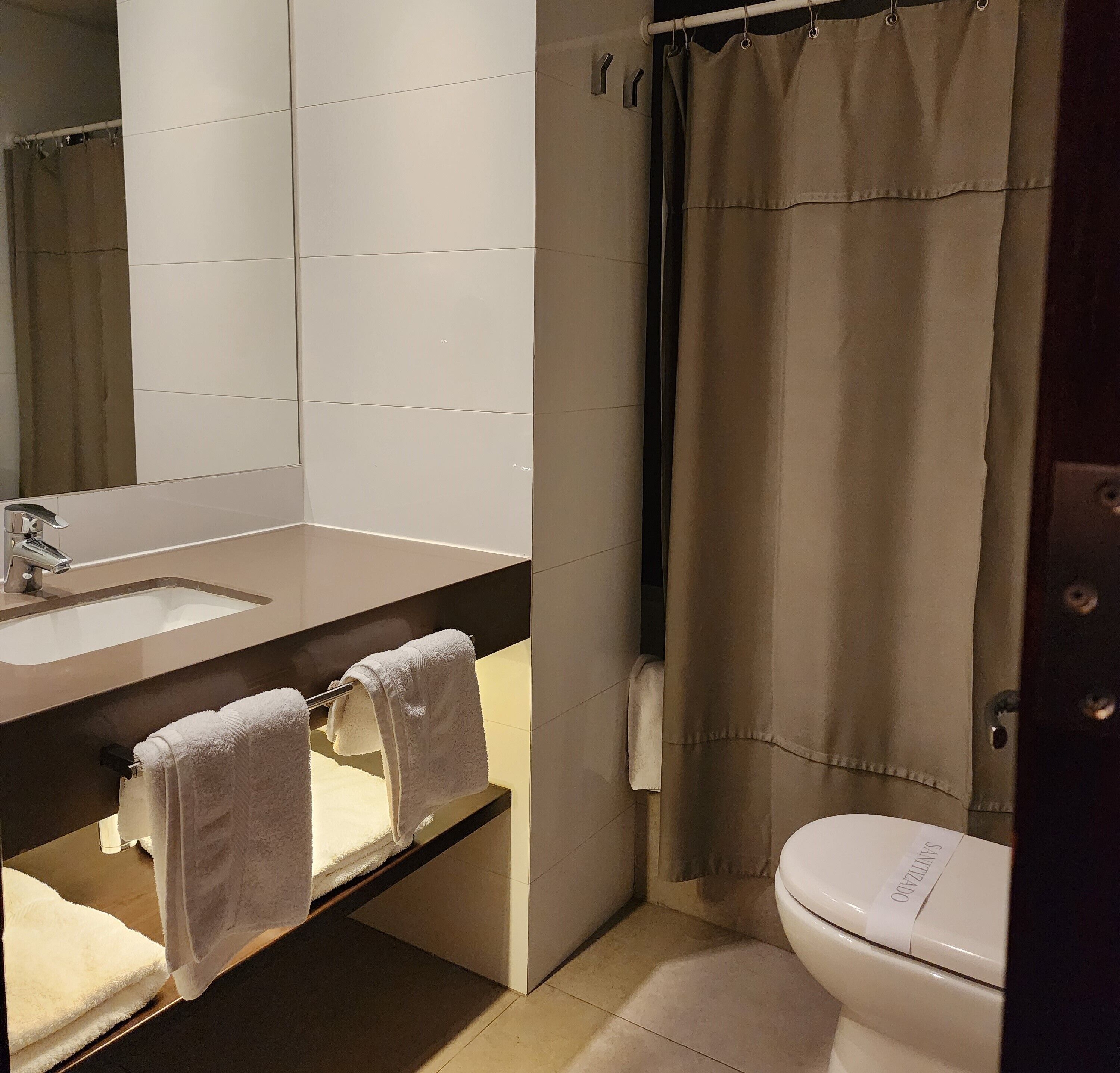 Une salle de bain avec un lavabo, un miroir et des toilettes.