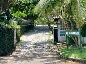 A paved pathway leading to a gated entrance with a sign for Summer Park.