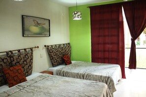 A room with two beds, a green wall, a butterfly painting, and a window with red curtains. - Hotel Cascada Huasteca (Tanchachin)