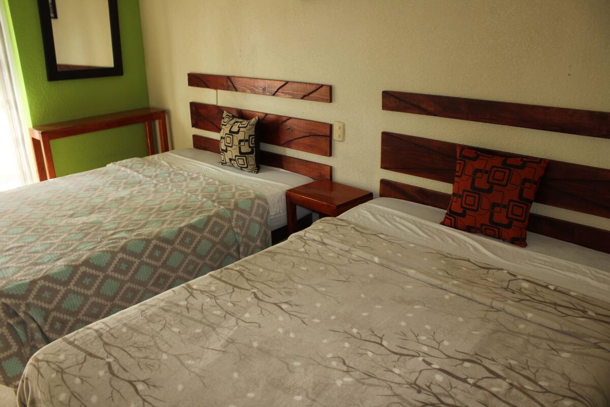 Two twin beds with patterned bedspreads, wooden headboards, and bedside tables with lamps.