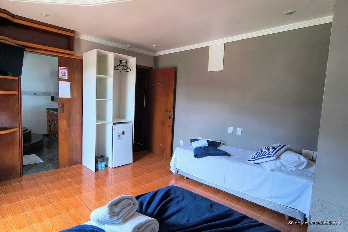 A bedroom with a bed, a wardrobe, and a bathroom.