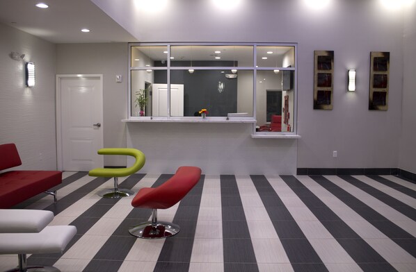 A waiting area with striped flooring, a reception desk, and modern chairs.