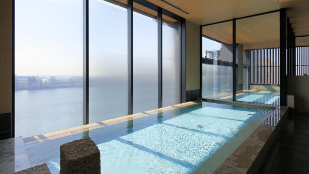 A modern indoor swimming pool with a city view, large windows, and a minimalist design. - The Singulari Hotel & Skyspa at Universal Studios Japan (Osaka)