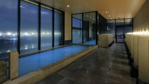 A modern indoor pool with a view of the cityscape at night. - The Singulari Hotel & Skyspa at Universal Studios Japan (Osaka)