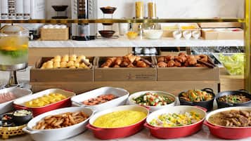 Una mesa de mármol con una variedad de alimentos, como pasteles, ensaladas y salsas.