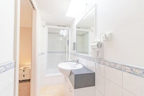 A bathroom with a white sink, a mirror, and a shower. - Warburton Lodge (Warburton)