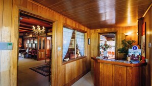 A wooden interior with a reception desk, a chandelier, and a staircase leading to another room. - Warburton Lodge (Warburton)