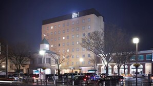 A multi-story hotel with a prominent sign, a parking lot, and a street with cars. - JR East Hotel Mets Fukushima (Fukushima)