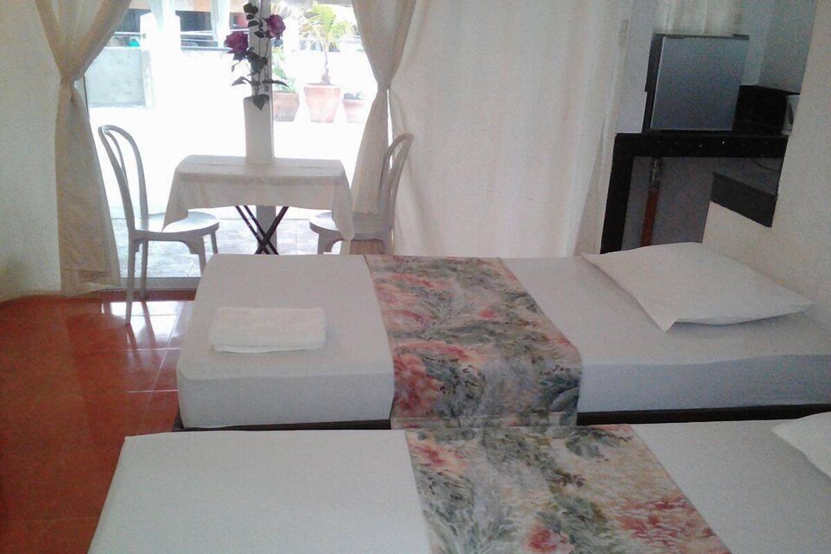 Una habitación de hotel con una cama, una mesita con sillas y un televisor.