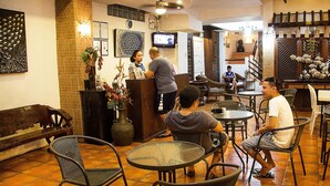 L’intérieur d’un restaurant, avec un comptoir d’accueil, un espace salon et des éléments décoratifs.