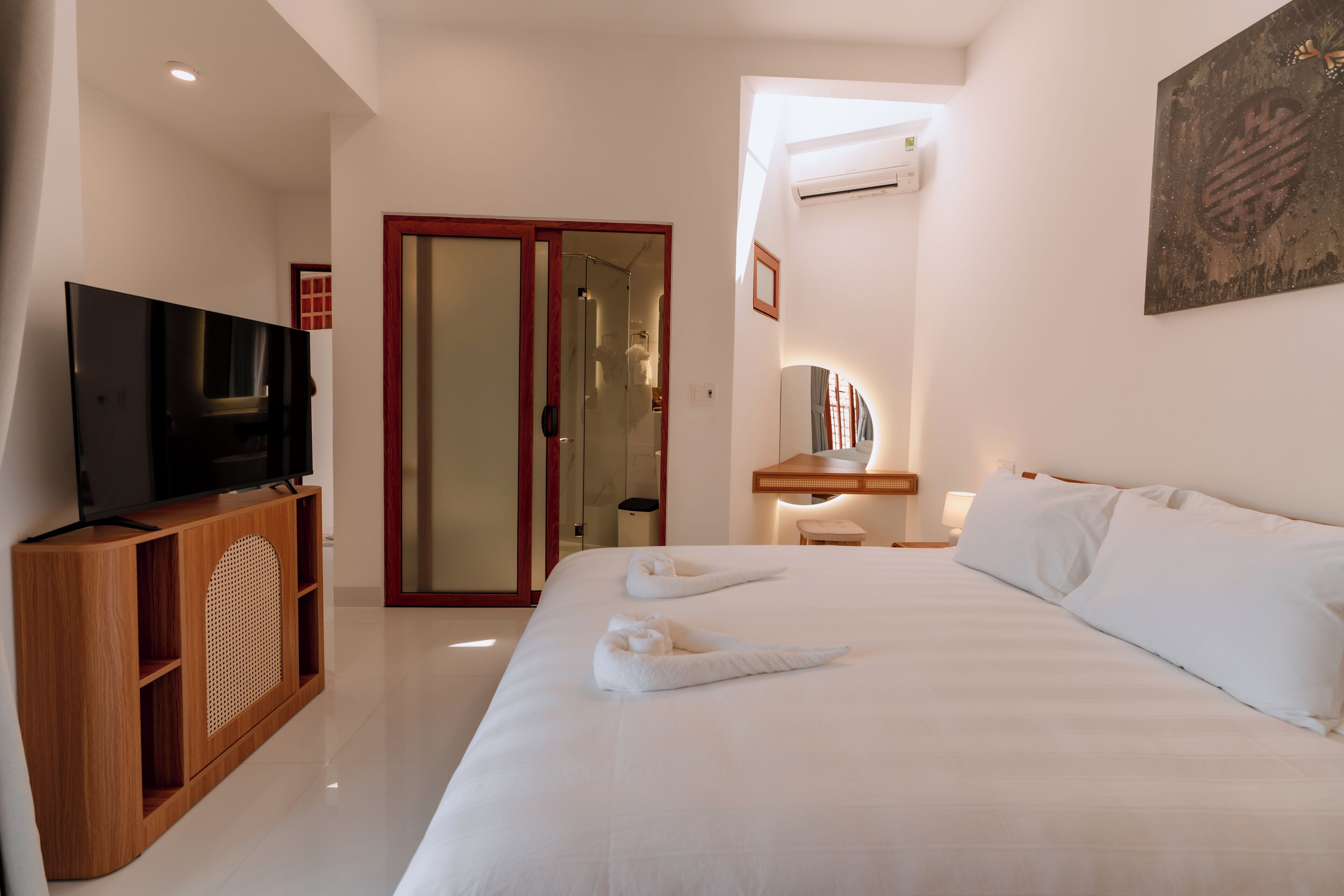A hotel room with a bed, a TV, a desk, and a wardrobe.
