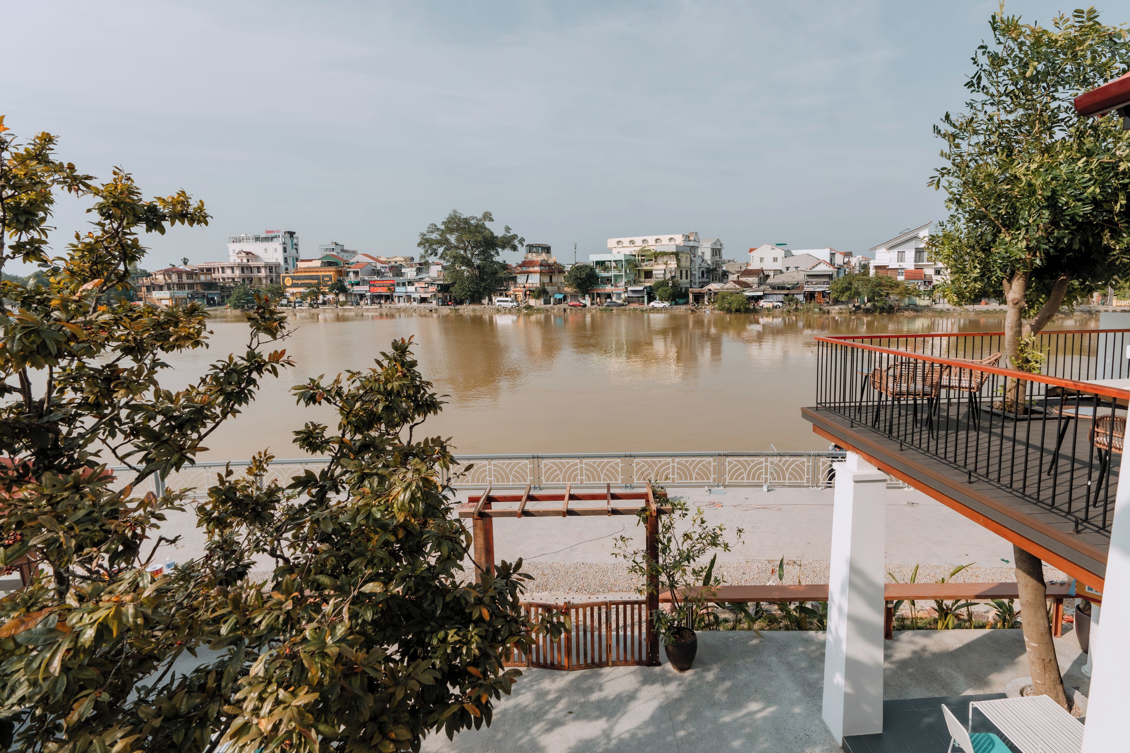 A view of a riverside area with buildings in the background.