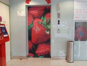 Un ascensor con una pared decorada con motivos de fresas.