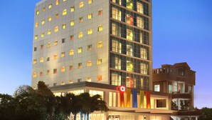 A multi-story hotel with a modern facade, large windows, and a prominent 'A' logo sign. - Amaris Hotel Padang (Padang)