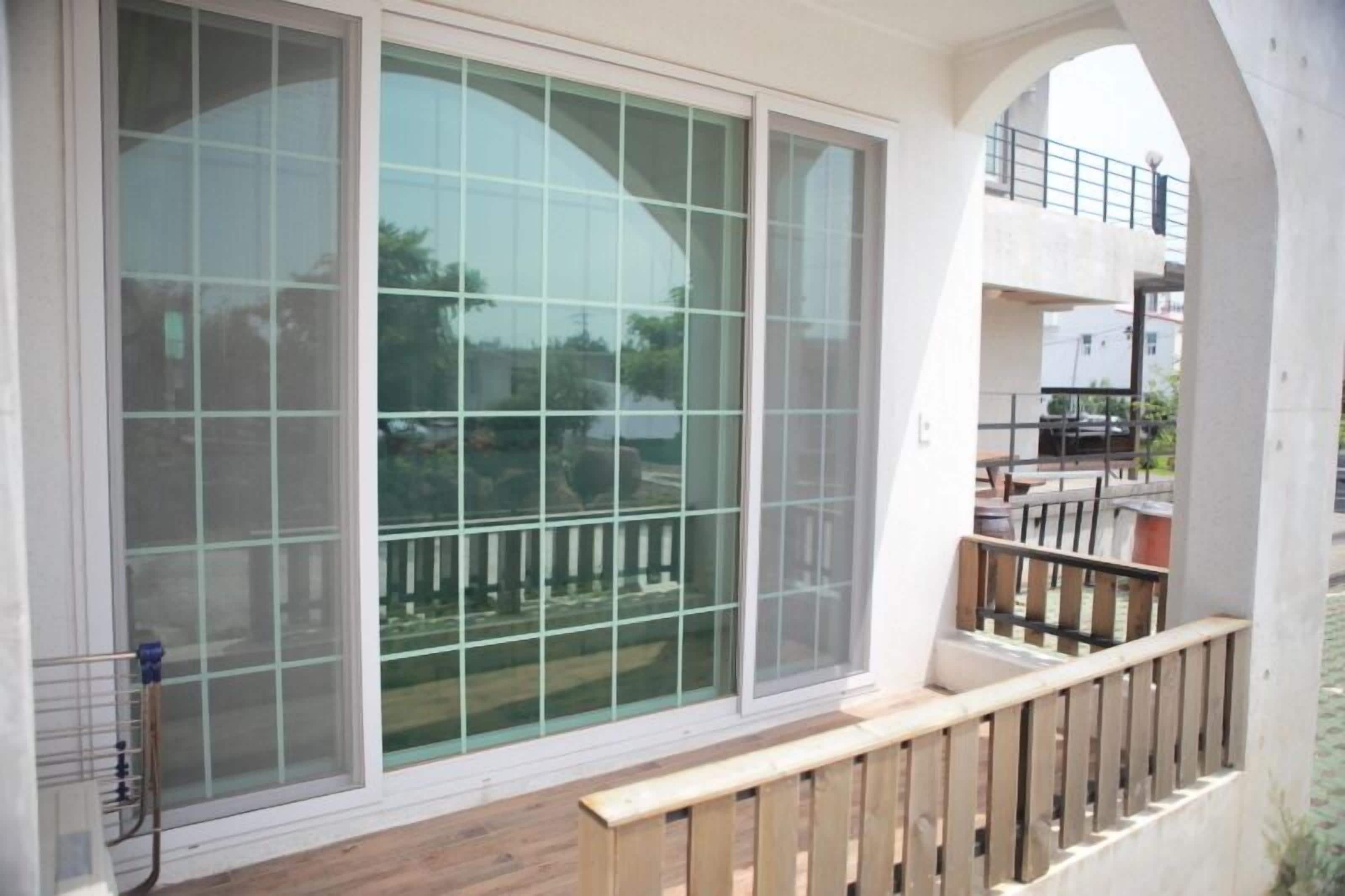 Un balcón con barandilla de madera y vista a una zona residencial.