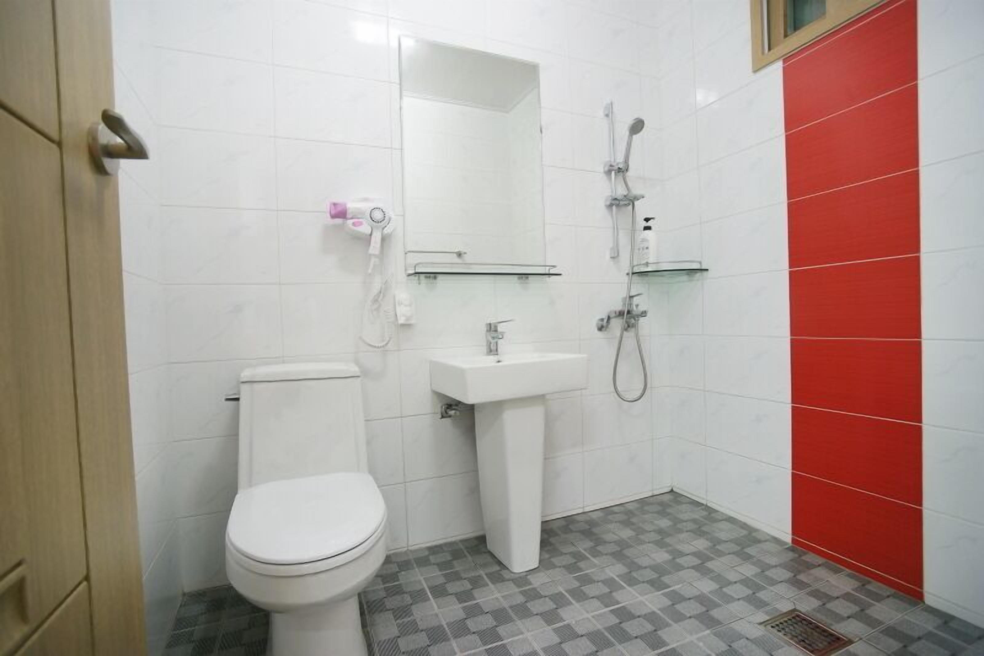A bathroom with a toilet, sink, and shower.