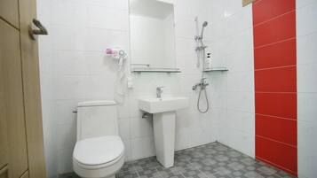 A bathroom with a toilet, sink, and shower.
