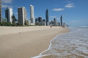 A beach with high-rise buildings in the background. - Queensleigh Apartment (Broadbeach)